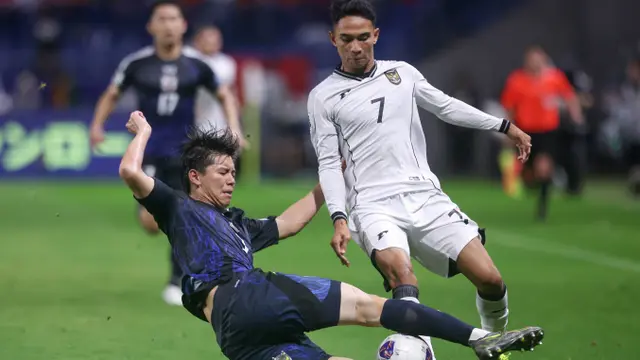 Gelandang Timnas Indonesia, Marselino Ferdinan mendapatkan tekel keras dari bek Timnas Jepang, Kota Takai dalam laga terakhir Grup C putaran ketiga Kualifikasi Piala Dunia 2026 di Suita City Football Stadium, Selasa (10/6/2025). (AFP/Paul Miller)