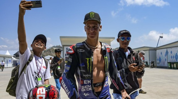 Quartararo tampak terkejut saat seorang fans mengajaknya nikah di arena MotoGP Mandalika 2025, dengan kerumunan penonton yang antusias di sekitar.