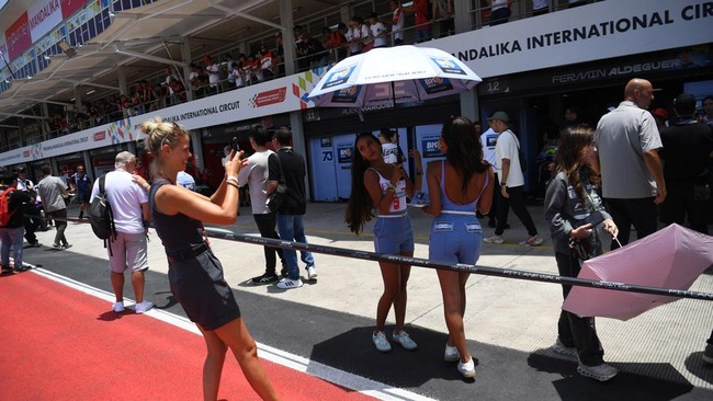 Penonton antusias menyaksikan langsung aktivitas tim dan pembalap di pit lane MotoGP Mandalika 2025, dengan suasana meriah dan penuh semangat.