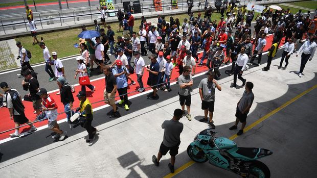 Penonton antusias menyaksikan langsung aktivitas tim dan pembalap di pit lane MotoGP Mandalika 2025, dengan suasana meriah dan penuh semangat.